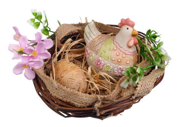 Easter nest with ceramic chicken and wooden egg. Isolated on white studio macro