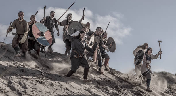 un gruppo di armi che brandisce guerrieri vichinghi su una duna sabbiosa sul campo di battaglia - dutch culture netherlands history historical reenactment foto e immagini stock