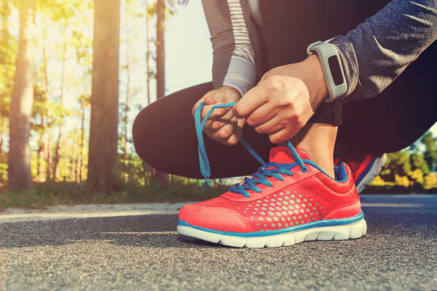istock Female jogger tying her shoes outside 1089035610