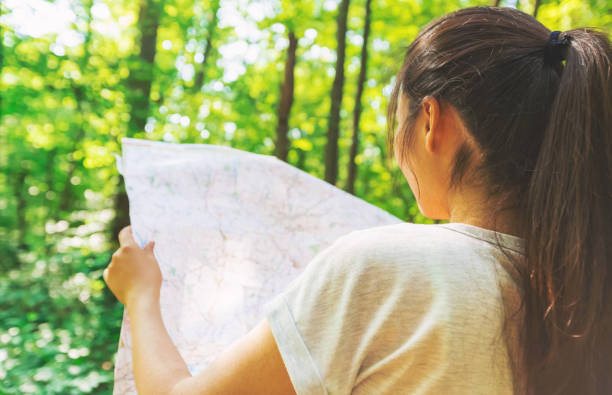 istock Woman in reading a map in the forest 1089035716