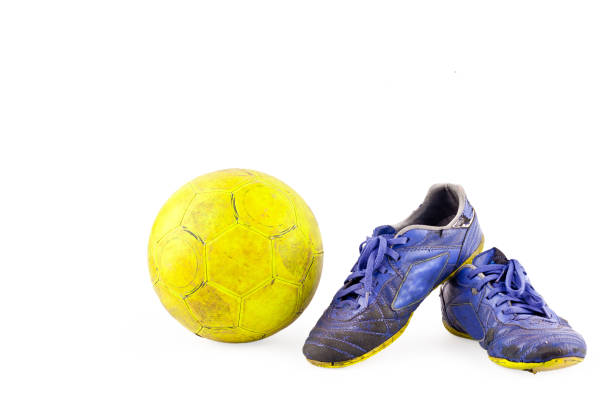 stary rocznik uszkodzone futsal buty sportowe i poszarpane żółtą piłkę na białym tle obiektu piłki nożnej izolowane - soccer ball old leather soccer zdjęcia i obrazy z banku zdjęć