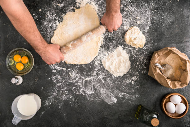 istock partial view of man rolling dough with wooden pin on grey background 1089040476
