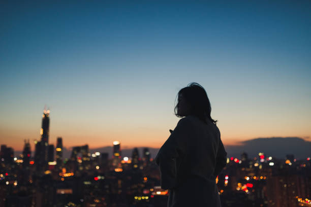 mujer mirando lejos en el pensamiento en la ciudad de - night cityscape reflection usa fotografías e imágenes de stock