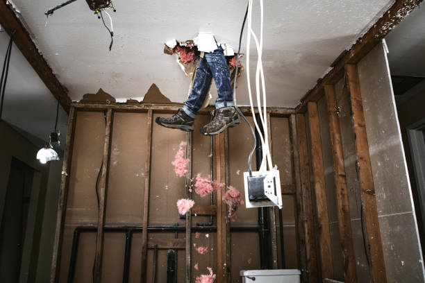 Contractor Man Doing Home Improvement and Demolition A man attempts to work on renovating his home, with funny and disastrous results.  He falls through the drywall ceiling feet first. moving down photos stock pictures, royalty-free photos & images