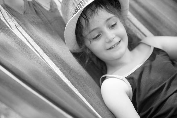 little girl swinging on a hammock in the garden at dusk