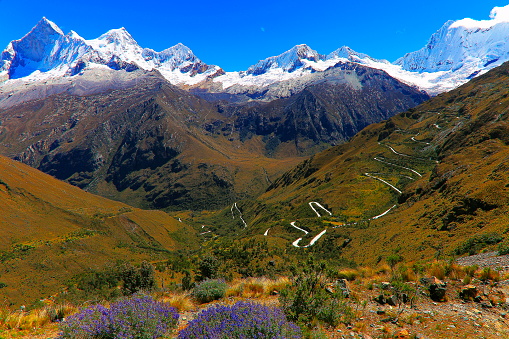 Portachuelo winding mountain Road pass in Cordillera Blanca, snowcapped mountain range in Peruvian Andes - Huaraz, Ancash region, Peru\n\nThe Portachuelo Llanganuco Pass, at an elevation of 4.767m (15.639') above the sea level, is perhaps the most significant gateway of the Huascaran National Park, Peru. The most challenging section of the road up to the pass is a 8.5km long section. Over this distance, the road includes 28 hairpin turns and the elevation gain is 527 meters. The average percentage is 6.2%. It’s one of the famous hairpinned roads in the world.\nThe road to the summit is called Carretera de Yungay (or Carretera 106). This gravel track has sheer drops on one side, and stone cliffs on the other; very sharp hair-pin turns and switchbacks. Since pre Inca times this has been the passageway straddling the continental divide.