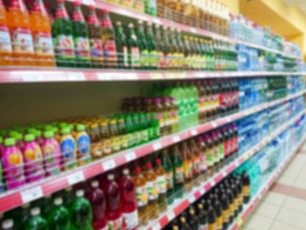 istock Blurred abstract image. Goods on the shelf of a grocery store. Various carbonated drinks and water in glass and plastic bottles 1089050858