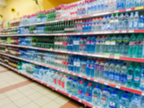 istock Blurred abstract image. Goods on the shelf of a grocery store. Water and various soft drinks in plastic and glass bottles 1089051888