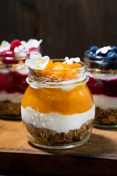 istock breakfasts in jars with muesli, berry puree and cream, vertical closeup 1089055378
