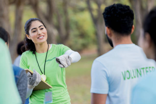 istock Female volunteer coordinator instructs volunteers during cleanup event 1089055464