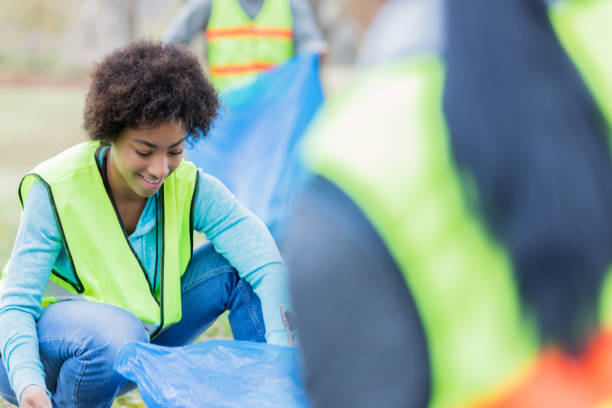 istock Young woman picks up garbage in community park 1089055556