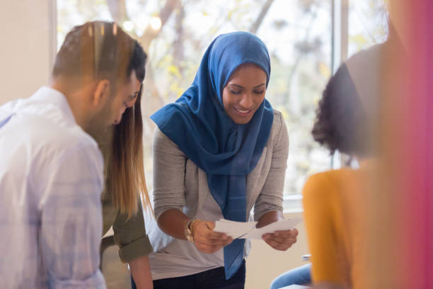 istock Creative group of people huddle around table to go over project 1089055694