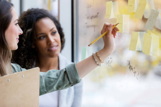istock Creative female writes on adhesive notes that stick to window 1089055716