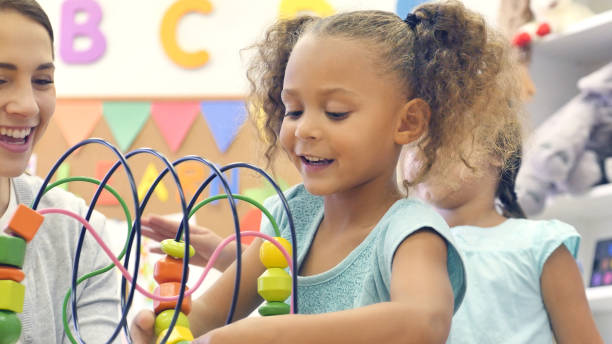 istock Young girl plays with toy in classroom 1089056048