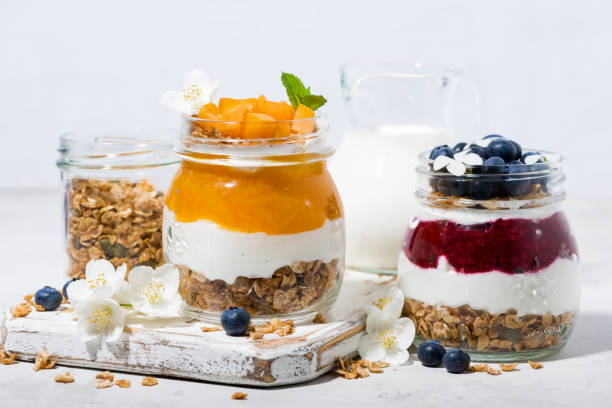 istock desserts with muesli, berry puree and fruit in jars on white table 1089056268
