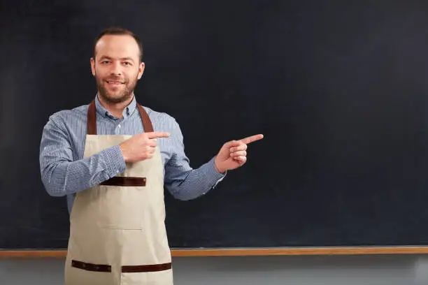 Photo of Cafe worker showing to blackboard.