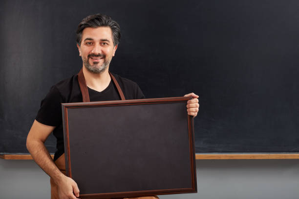 istock Cafe owner holding placard on blackboard. 1089060816