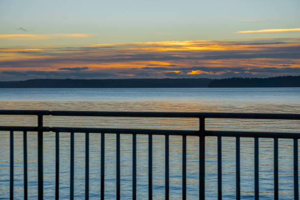 A view of a sunset with a fence from West Seattle, Washington.