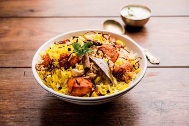 indian chicken tikka biriyani serviert in einer schüssel mit joghurt. selektiven fokus - nonvegetarian stock-fotos und bilder
