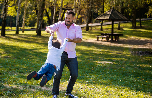 Cheerful mixed race family have a fun in public park