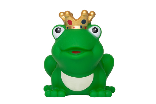Rubber frog toys. Funny cute rubber green frog king or frog prince toy isolated on a white background. Macro.