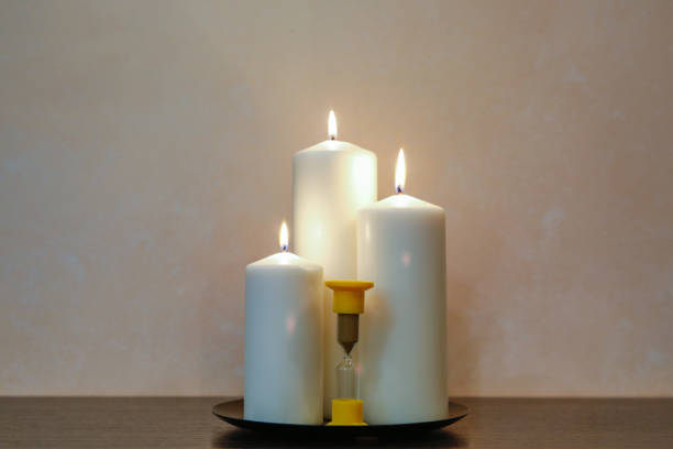 istock old hourglass and wax candle on the table 1089089180