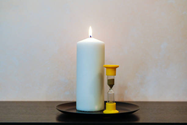 istock old hourglass and wax candle on the table 1089089222