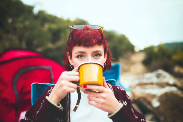 istock red haired young woman drinking coffee in nature 1089091326