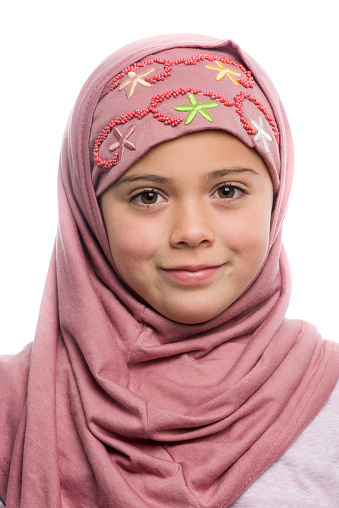 Smiling muslim little girl looking at the camera on white background
