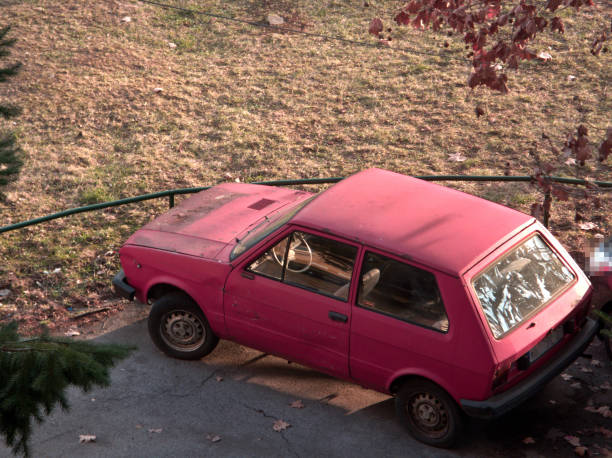 istock Red oldtimer car at the parking lot by public park 1089093704