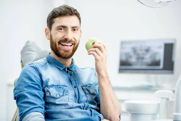 Portrait of a handsome bearded man with healthy smile in the dental office