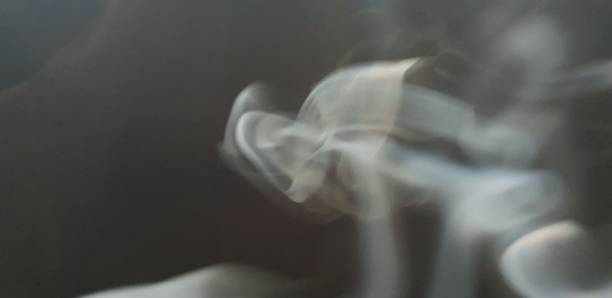 istock Wispy twirls of incense smoke against dark background with copy space 1089096692