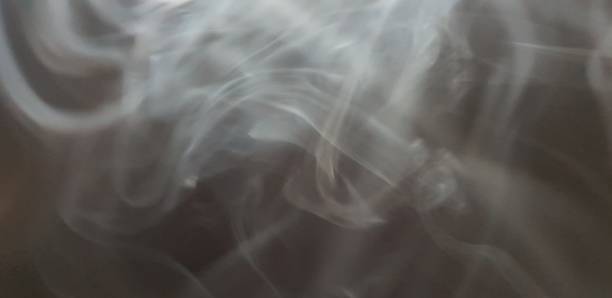 istock Wispy twirls of incense smoke against dark background with copy space 1089096784