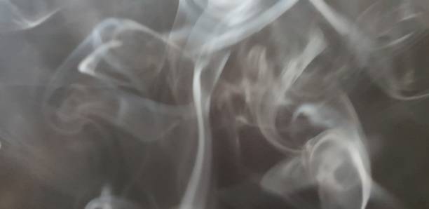 istock Wispy twirls of incense smoke against dark background with copy space 1089096850