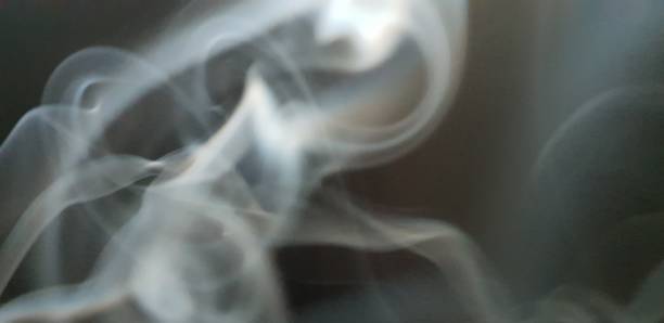 istock Wispy twirls of incense smoke against dark background with copy space 1089097082