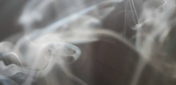 istock Wispy twirls of incense smoke against dark background with copy space 1089097132