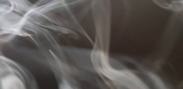 istock Wispy twirls of incense smoke against dark background with copy space 1089097264