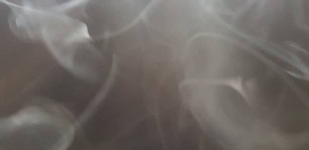 istock Wispy twirls of incense smoke against dark background with copy space 1089097286