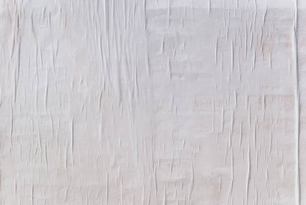 texture of wet white folded paper on an outdoor poster wall, crumpled paper background - paper folded crumpled textured imagens e fotografias de stock