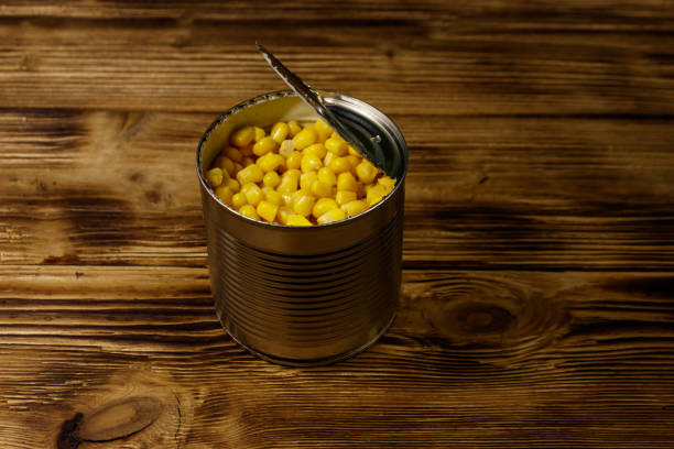 istock Open tin can of corn on wooden table 1089109610