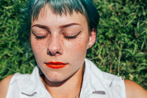 istock Charming girl with freckles laying on grass 1089114122