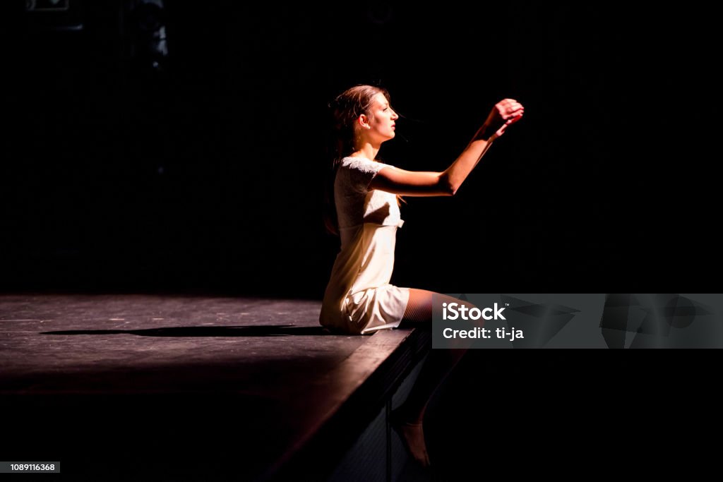 Young dancer performing on a theater stage Young caucasian dancer performing on a theater stage. Theatrical Performance Stock Photo