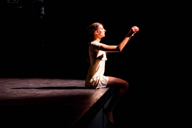 Young dancer performing on a theater stage Young caucasian dancer performing on a theater stage. theater industry stock pictures, royalty-free photos & images