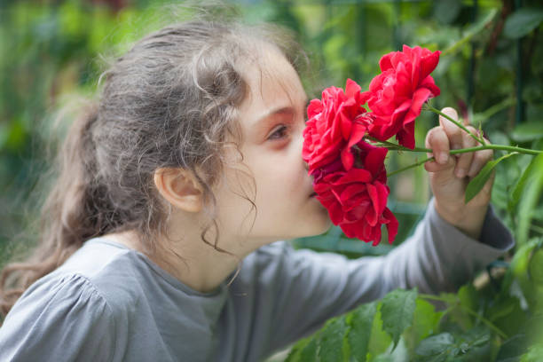 istock Little girl sniffs flowers 1089119298