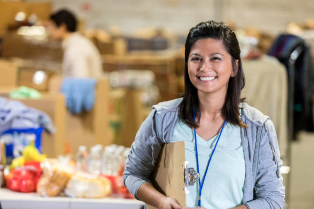 istock Female smiles while standing in a warehouse with clipboard 1089122736