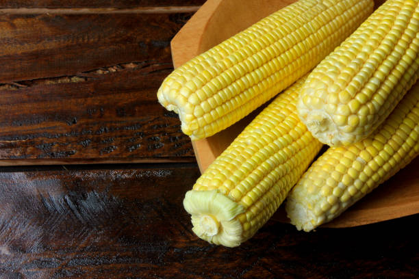 istock Raw corn kernels inside wood bowl on rustic wooden table. space for text. Top view. 1089124404