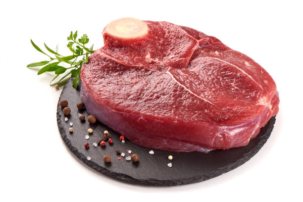 istock Fresh raw beef meat with bone for steak on stone plate, isolated on white background 1089126670