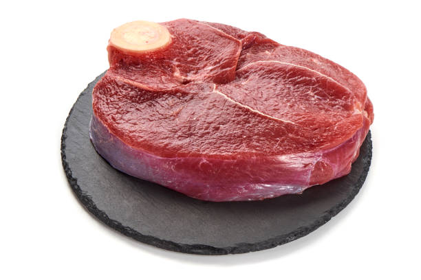 istock Fresh raw beef meat with bone for steak on stone plate, isolated on white background 1089128114