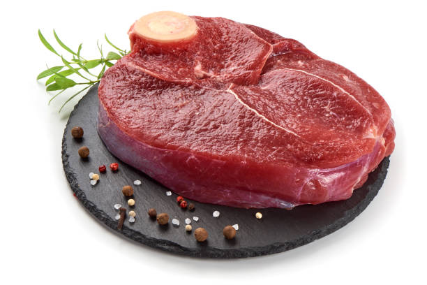 istock Fresh raw beef meat with bone for steak on stone plate, isolated on white background 1089128126