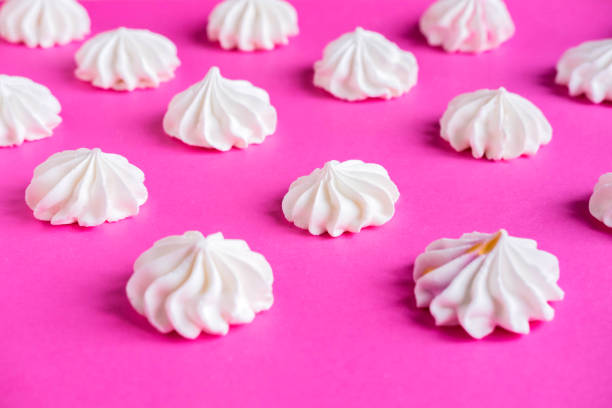 istock Frame for backing with a meringue on a pink background. Basis for design with multicolored meringues on a pink background. Basis for confectionery banner, cafe, sweet shop 1089132678